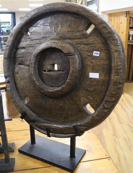 A Thai carved wood wheel on stand diameter 75cm